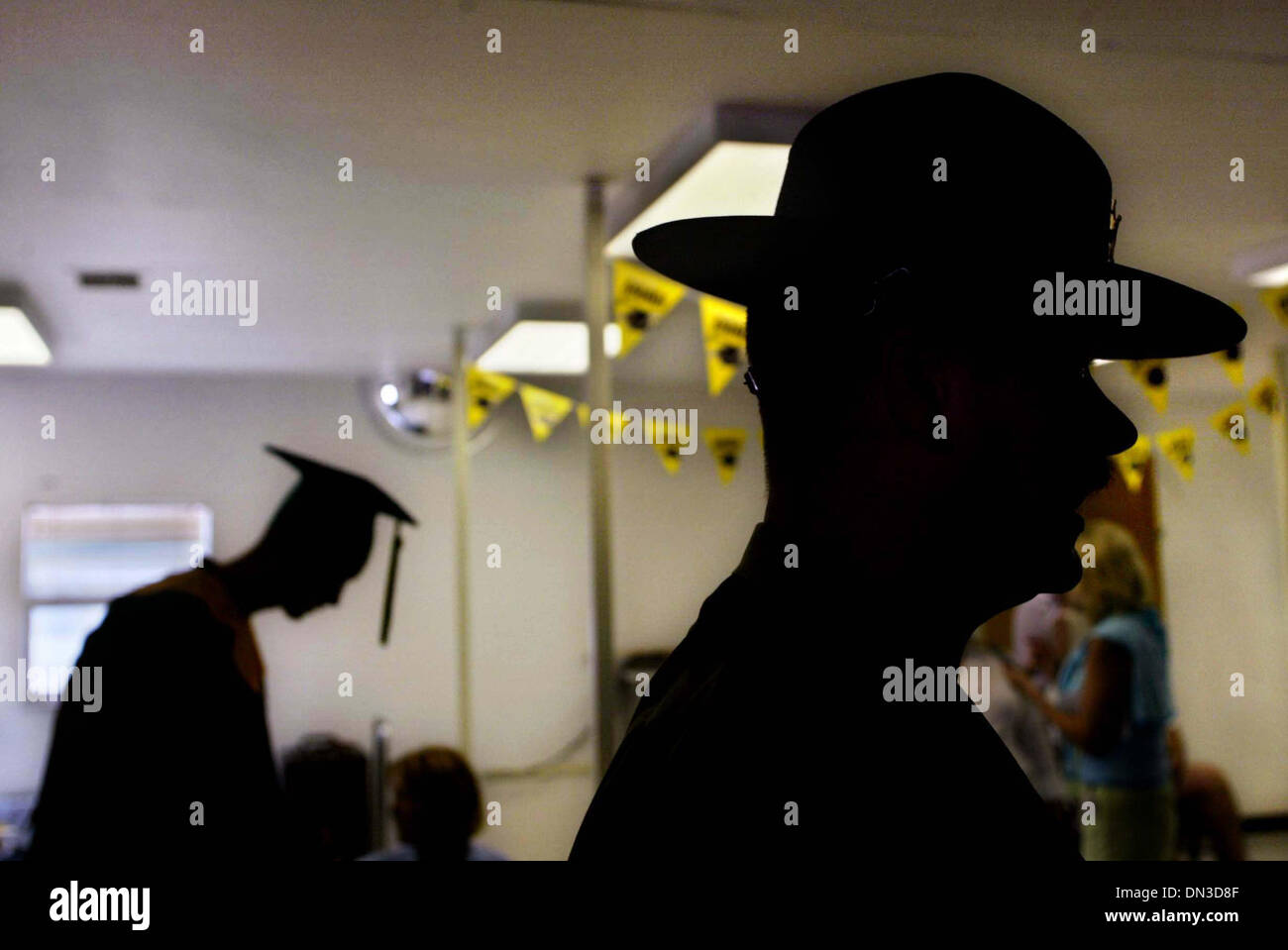 Jun 09, 2006; Stuart, FL, USA; DI J.Bowdoin, right, and graduate Miguel Huaman, 17, left rear, Port St. Lucie, attend the Martin County Sheriff's Office Juvenile Offender Training Center High School graduation reception after Friday's ceremony. Mandatory Credit: Photo by Amanda Voisard/Palm Beach Post/ZUMA Press. (©) Copyright 2006 by Palm Beach Post Stock Photo