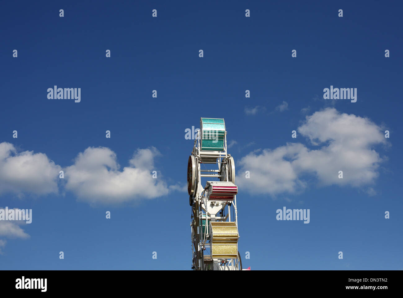 A carnival ride called the Zipper, against a blue sky with a few puffy