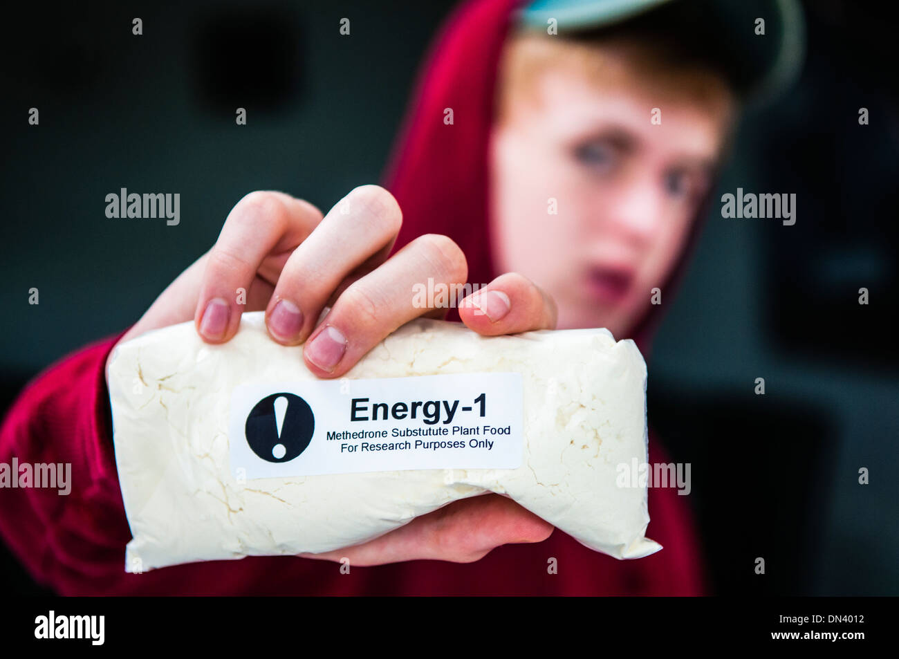Teenage boy holds a package containing 200g of Naphyrone (Energy-1/NRG-1), a 'legal' designer drug which has killed hundreds Stock Photo