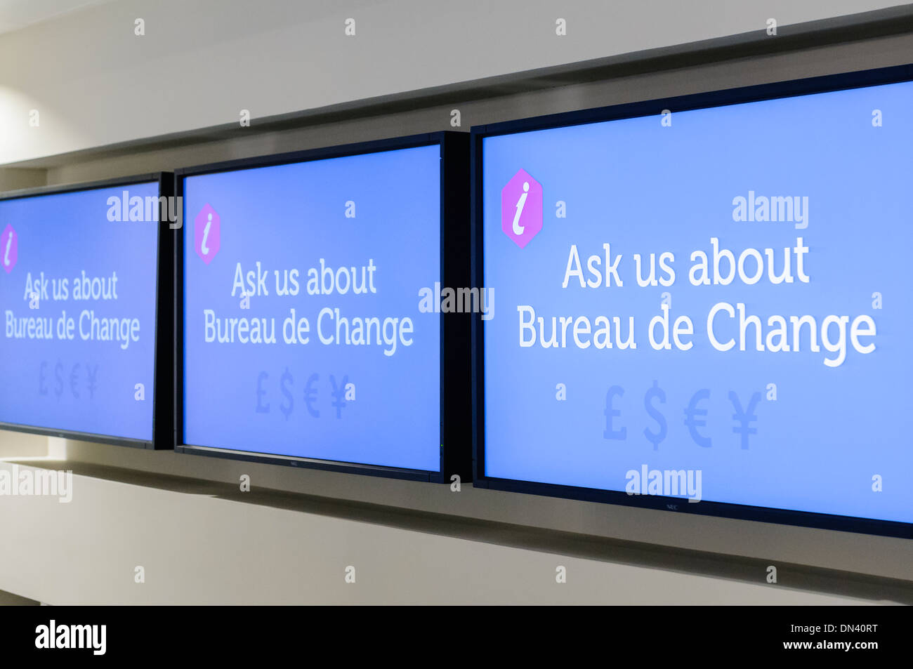 Screens in a tourist information office asking visitors to ask about Bureau de Change facilities Stock Photo