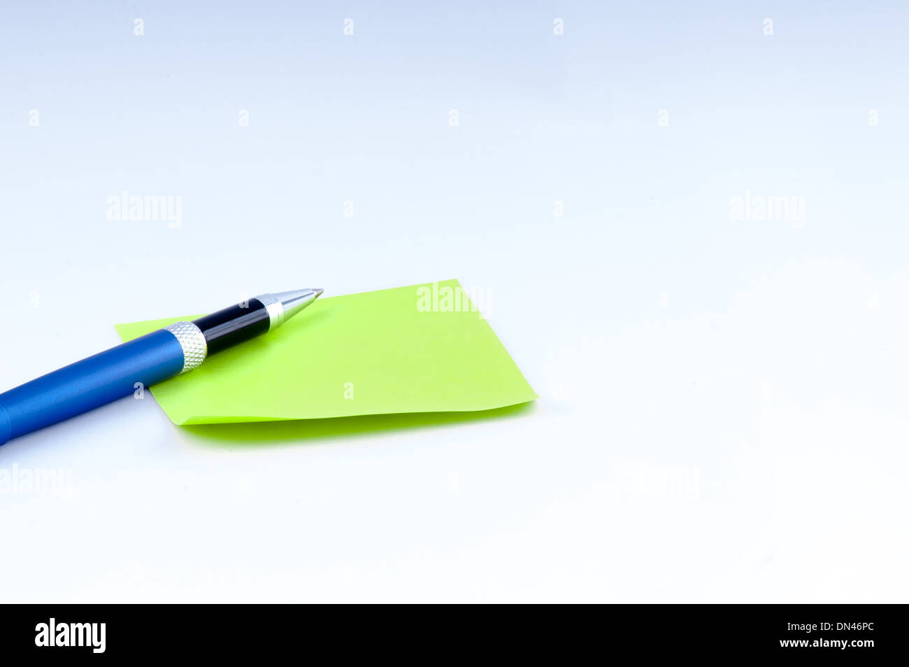beautiful blue pen and blank adhesive note on white background. center left Stock Photo