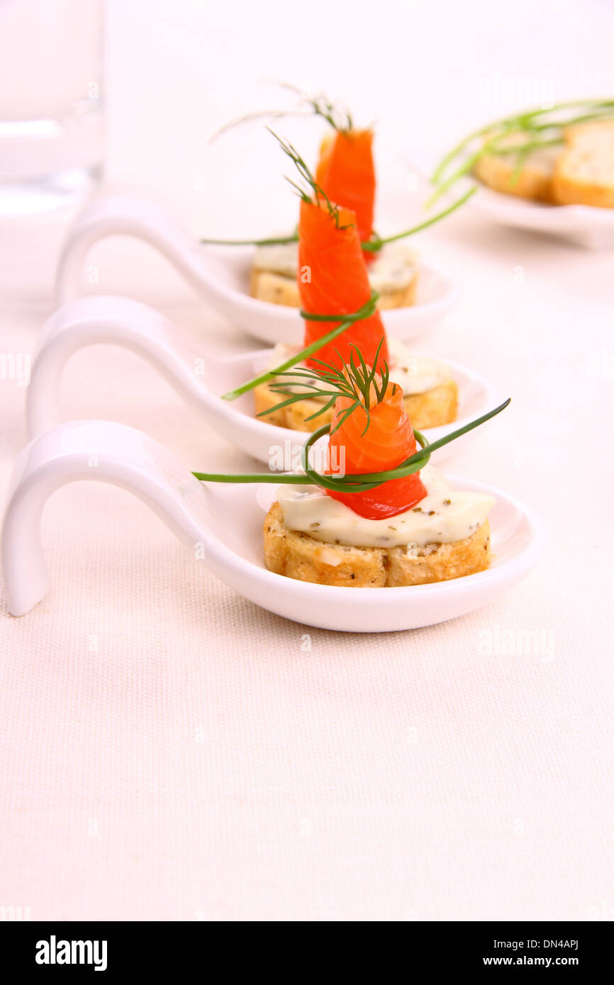 Smoked Lachsrollchen on white bread chunks, vertical Stock Photo