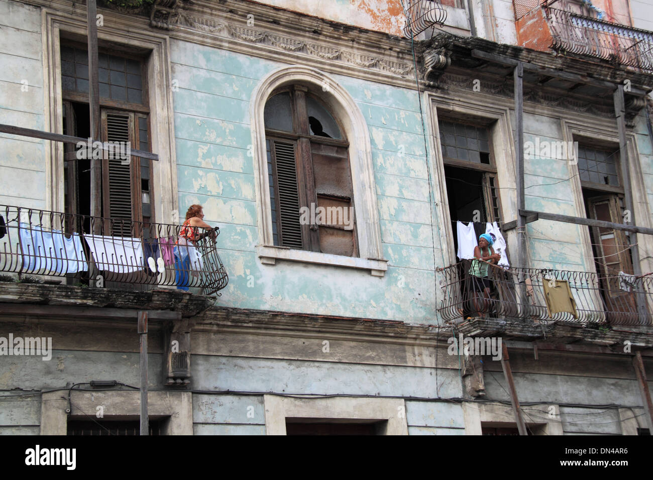 Ladies talking on their crumbling balconies, Calle Industria, Old Havana (La Habana Vieja), Cuba, Caribbean Sea, Central America Stock Photo