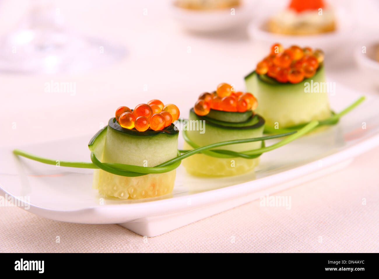 Red caviar on fresh cucumber as snack, close up Stock Photo