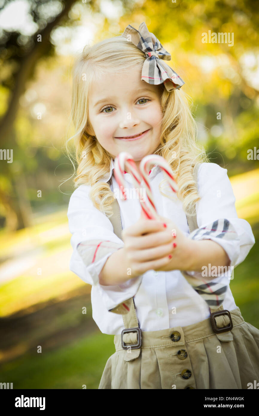 Cute Little Girl with a Bow in Her Hair Holding Her Christmas Candy