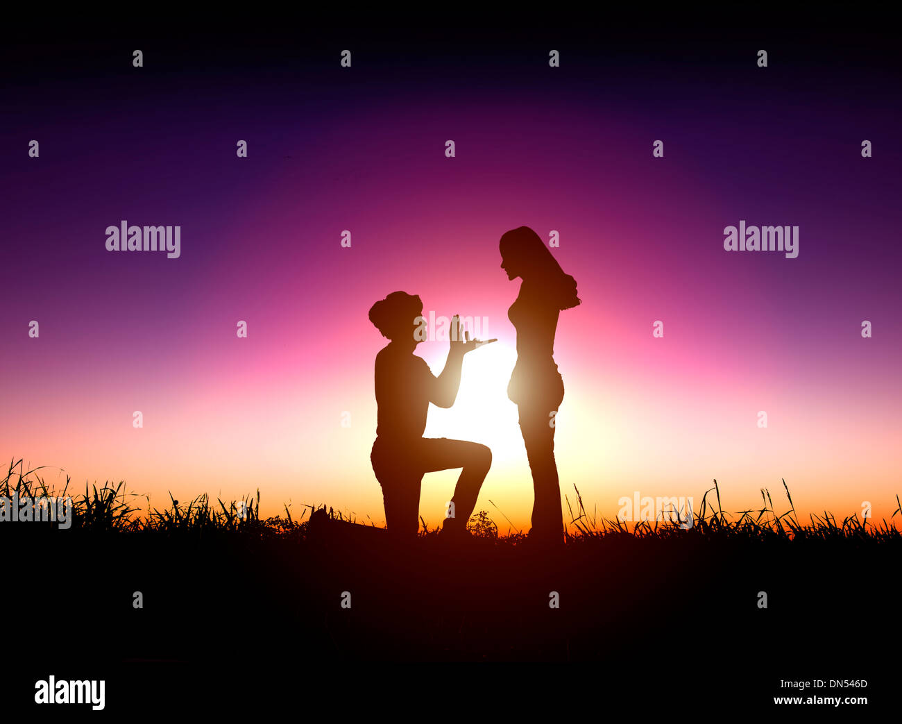 man proposes a woman to marry with sunrise background Stock Photo