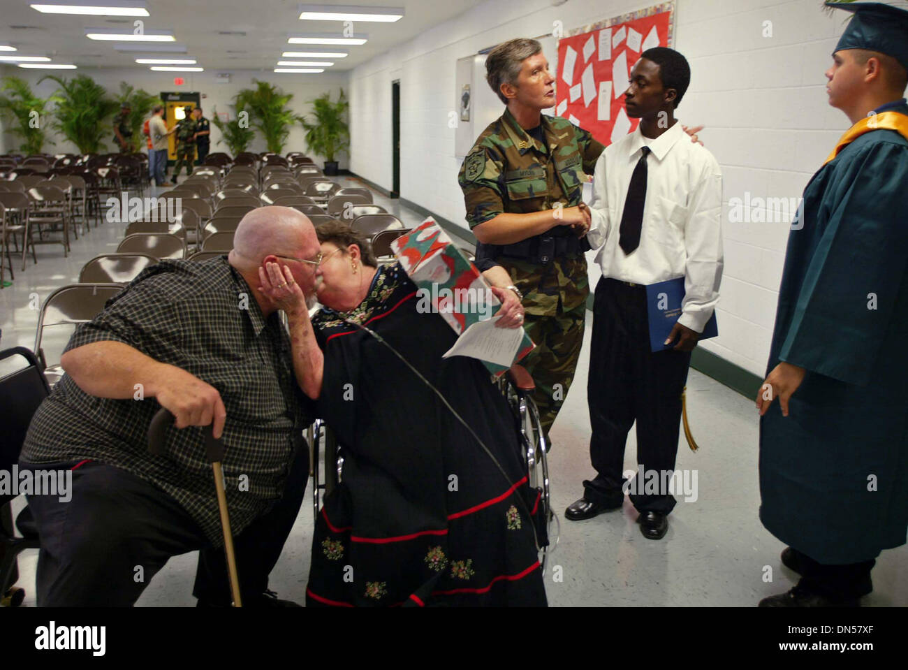 Jun 09, 2006; Stuart, FL, USA; Employee Terry Rogers gives a kiss to retiree, Kathy Crostic as Sgt. Yvonne Myles congratulates Jamelle Smith, 18 Delray Beach following graduation ceremonies for the Martin County Sheriff's Office Juvenile Offender Training Center, Friday. Mr. Rogers will be retiring upon the closing of the institution and Ms. Crostic retired recently after working f Stock Photo