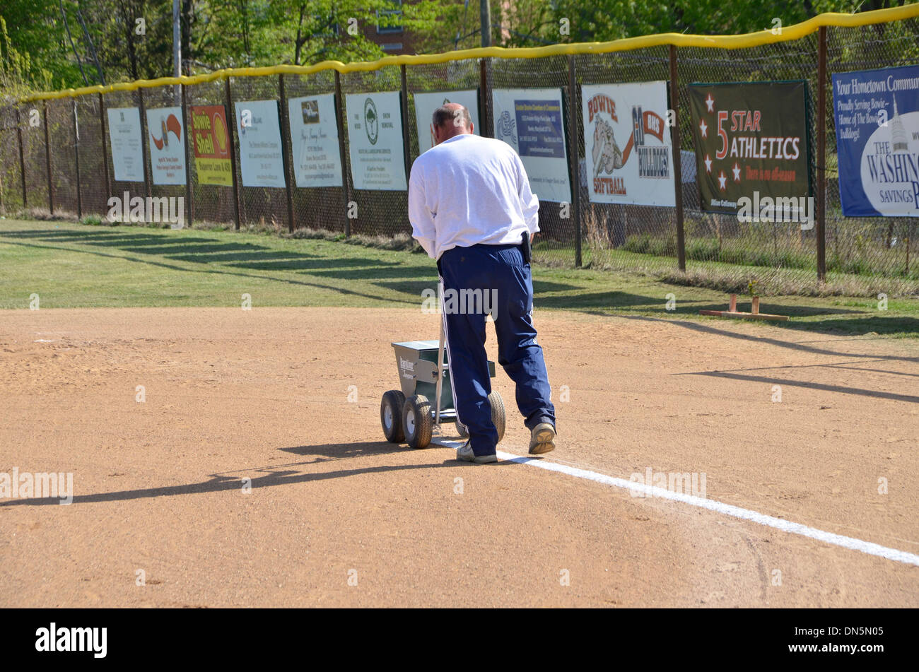 Coach preps the field for a softball game game in Bowie, Maryland Stock Photo