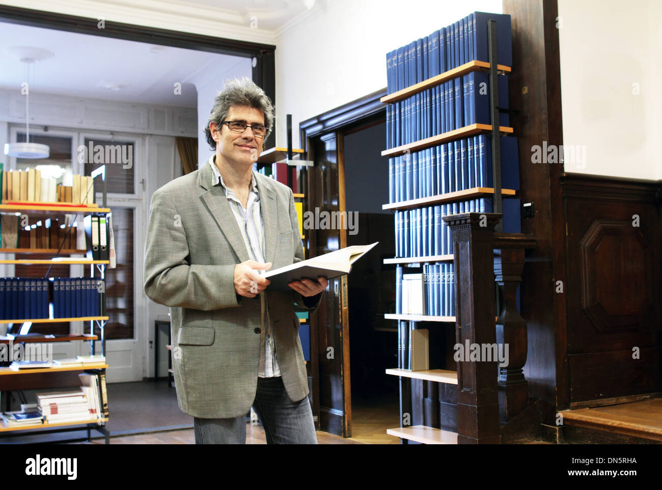 a man in a library wit a book Stock Photo