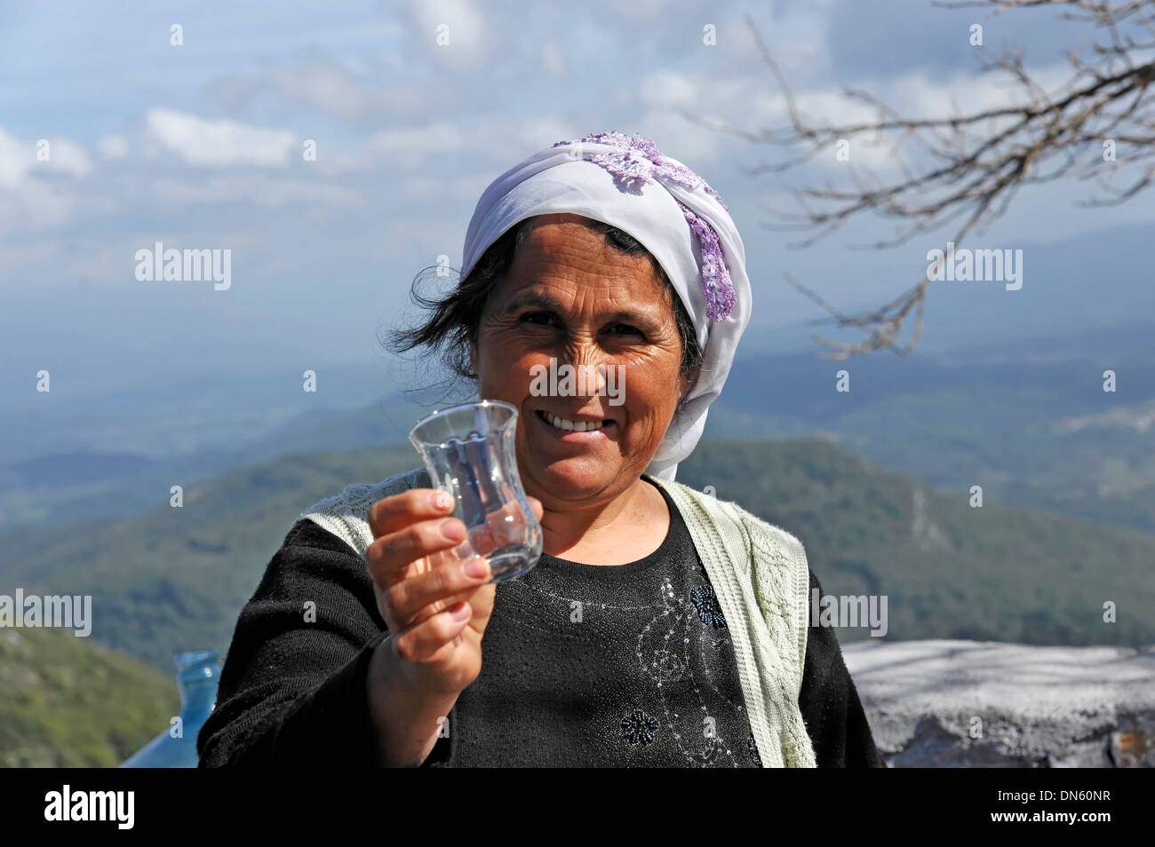 Turkish woman passing a glass in Akyaka, Muğla Province, Turkey Stock Photo