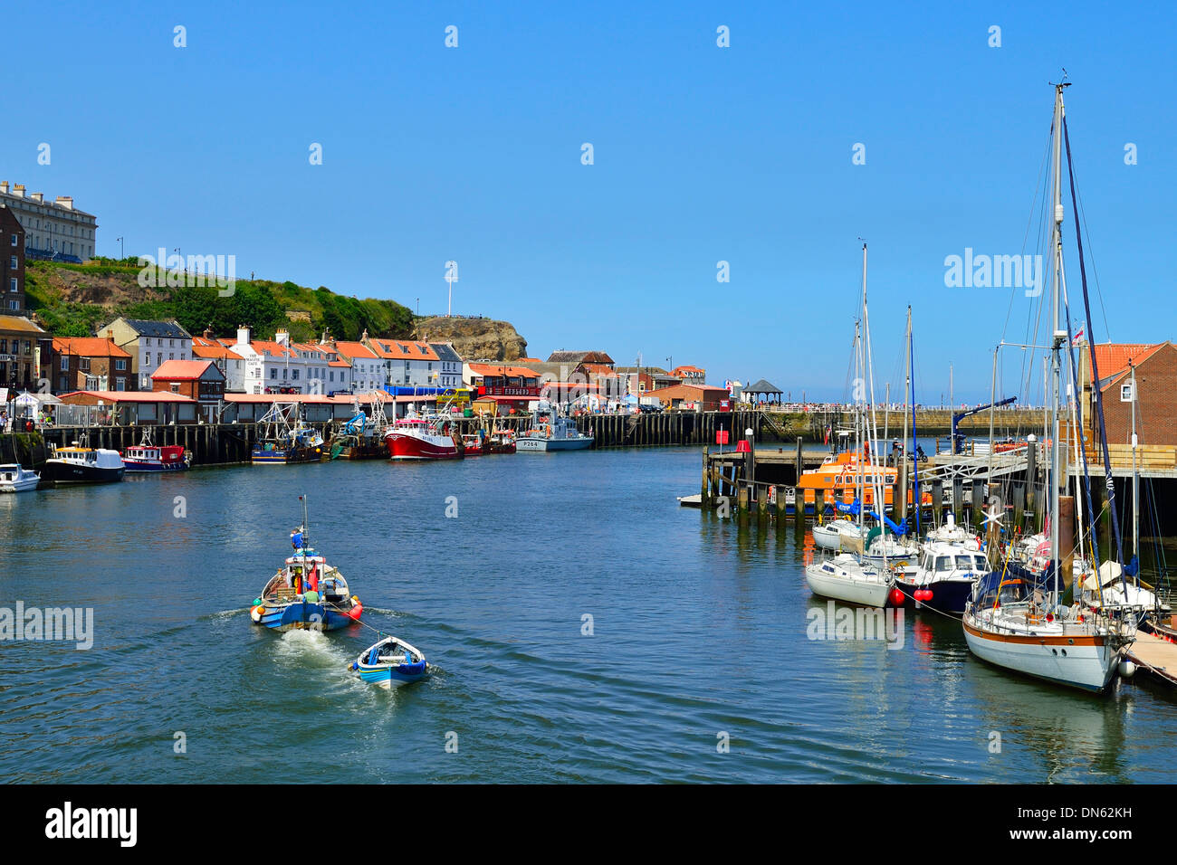 A fishing boat leaving the harbour, Whitby, North Yorkshire, England, United Kingdom Stock Photo