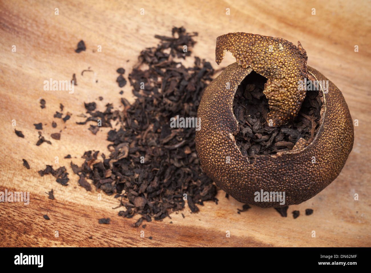 Pu-erh. Chinese tea packed in dried mandarin on wooden table Stock Photo