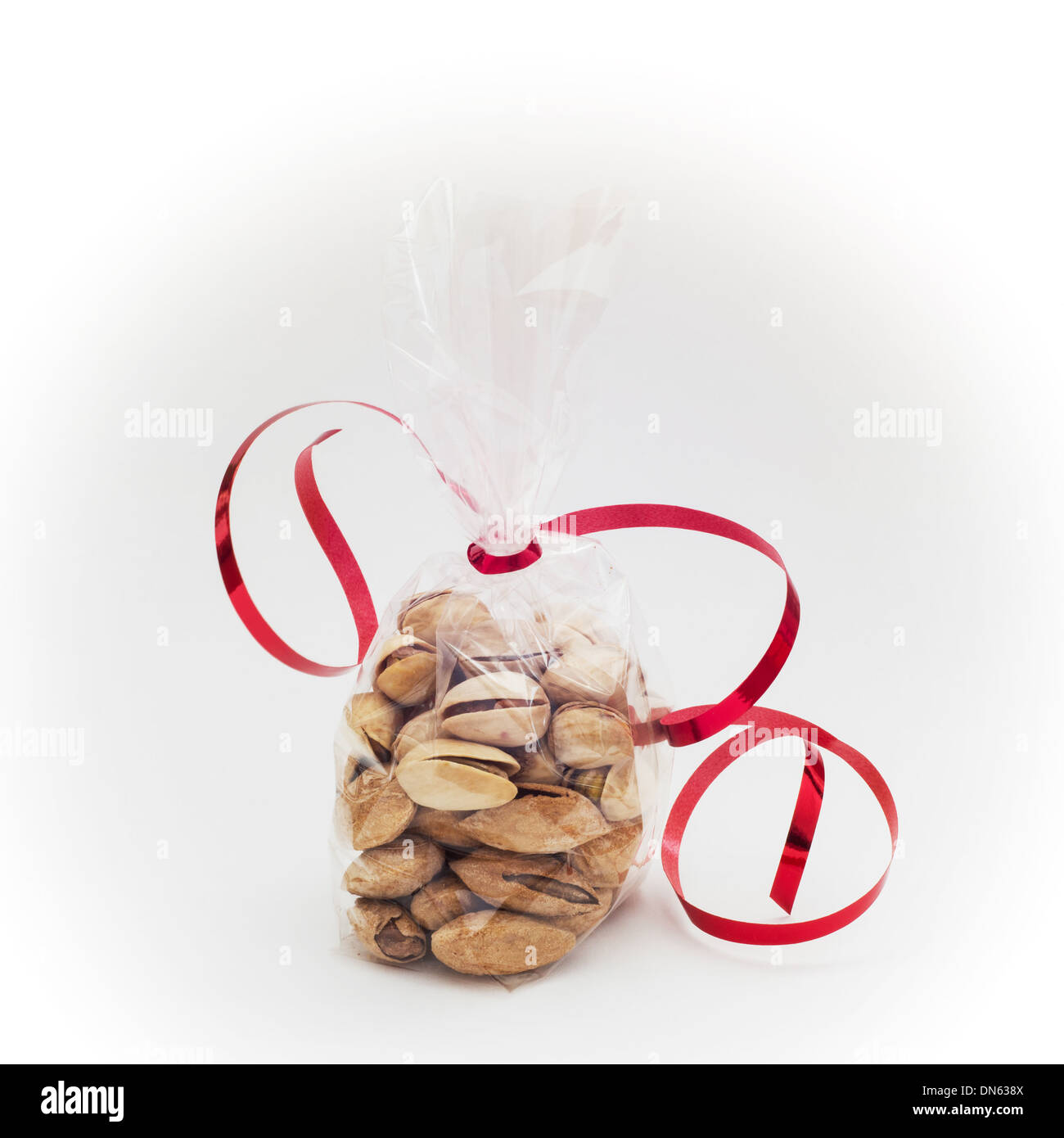 Pistachios in mini bag with red bow on a white background Stock Photo
