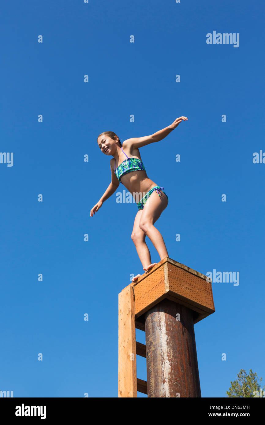 Mixed race girl jumping off platform Stock Photo