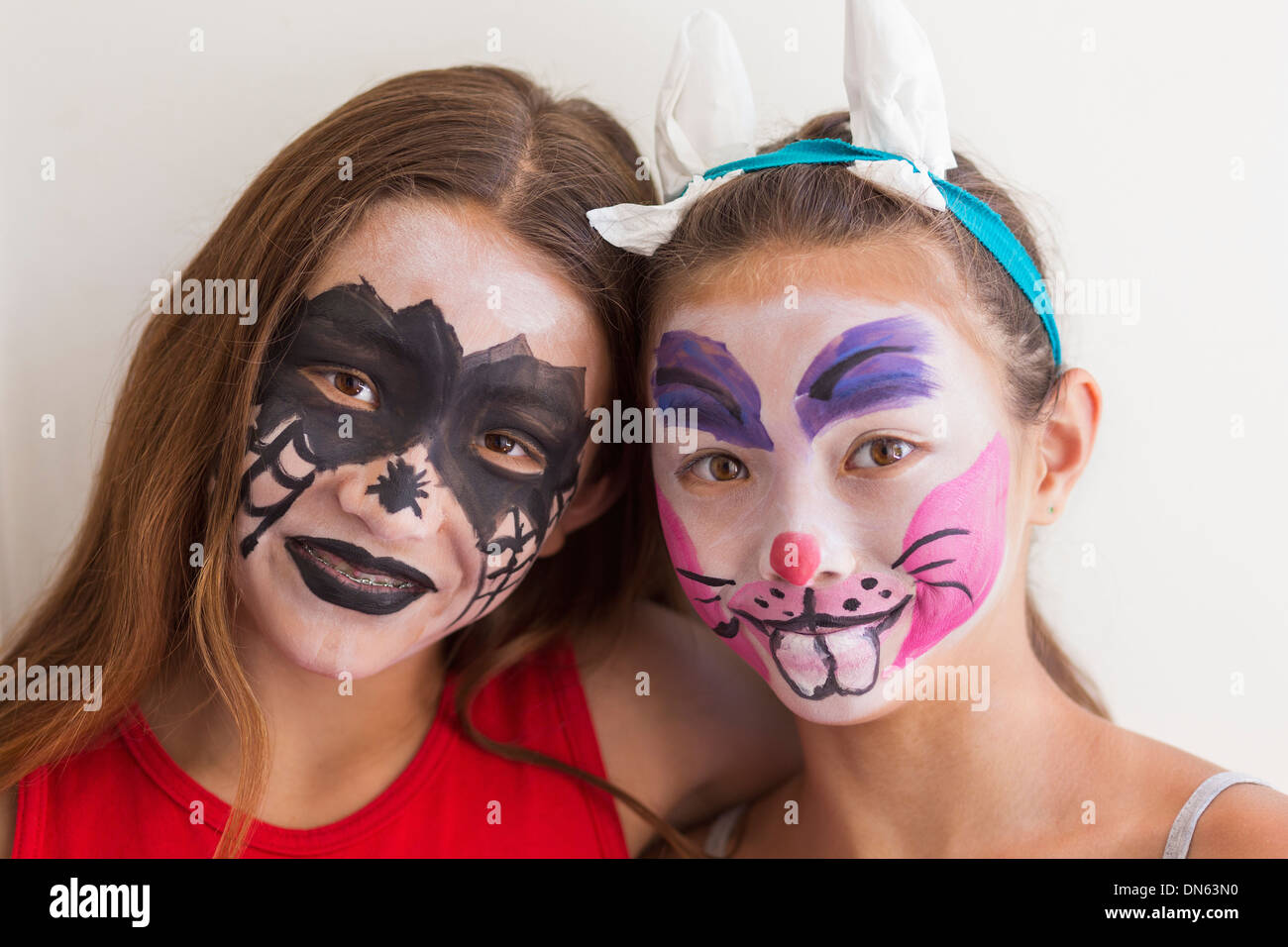 Mixed race girls wearing face paint Stock Photo