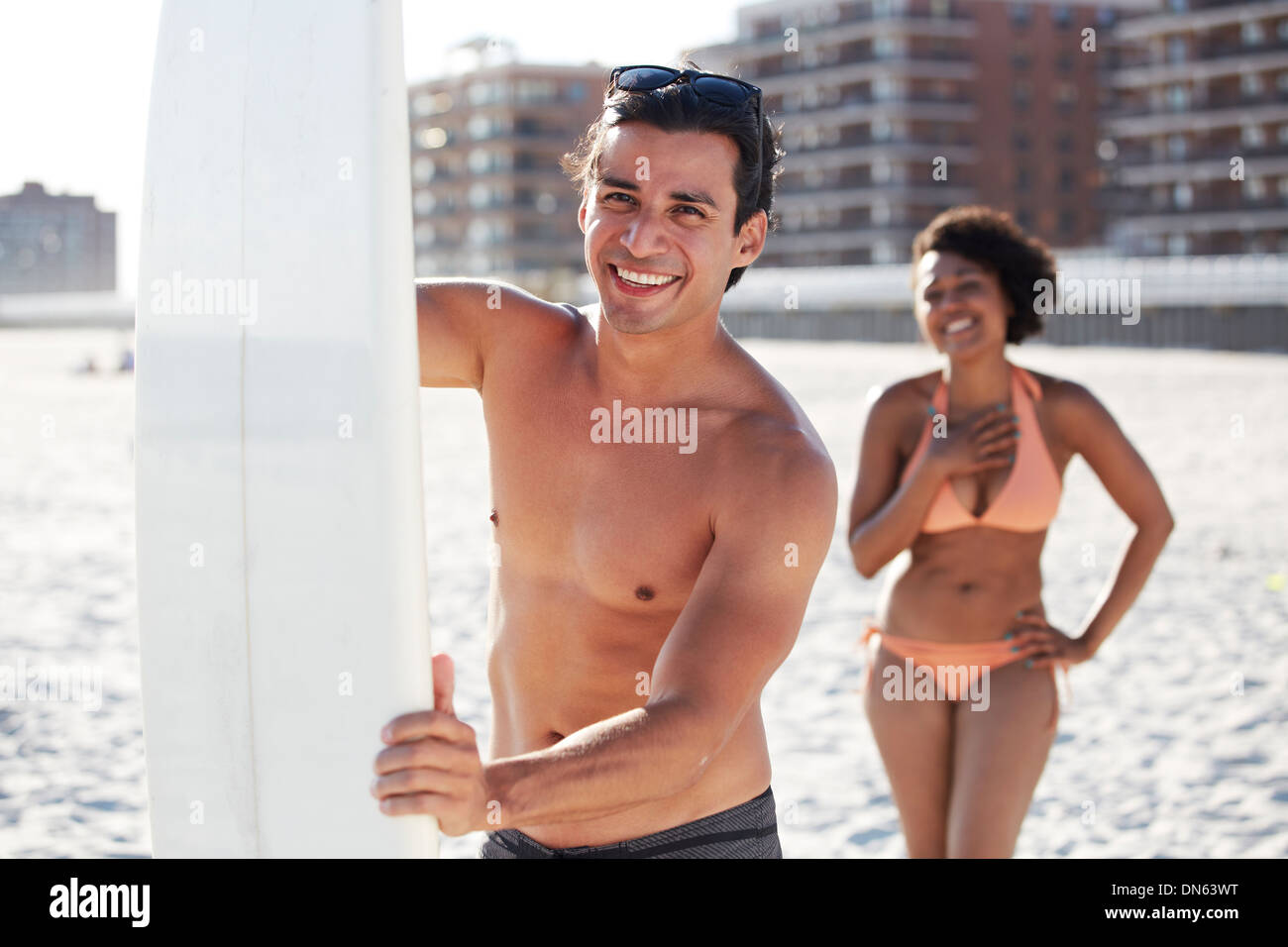 Couple with surfboard on beach Stock Photo