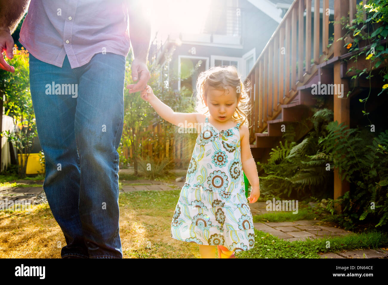 Father and daughter walking in backyard Stock Photo - Alamy
