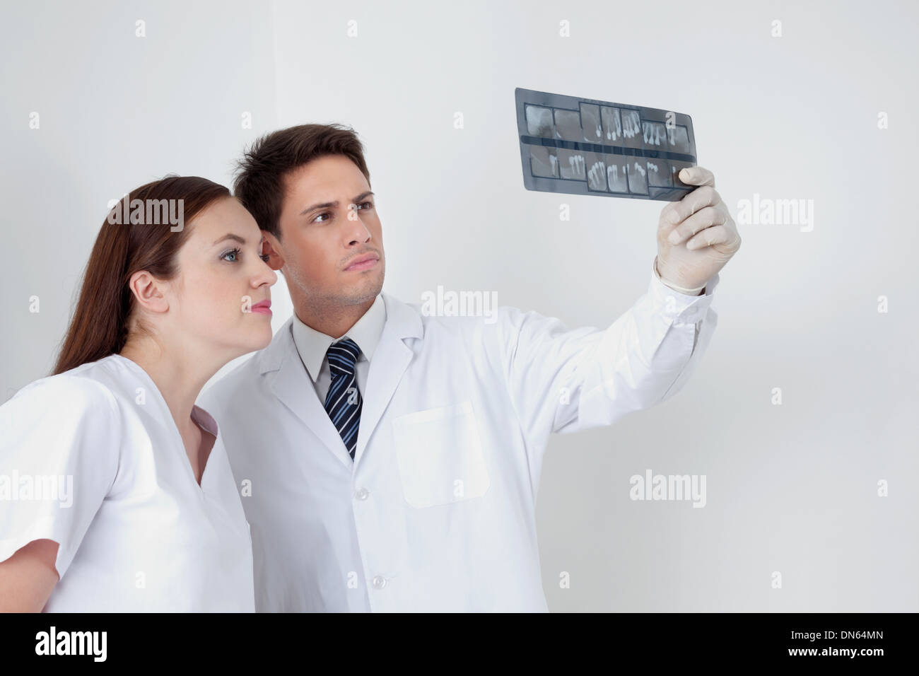 Doctor And Assistant Analyzing Patient's Report Stock Photo