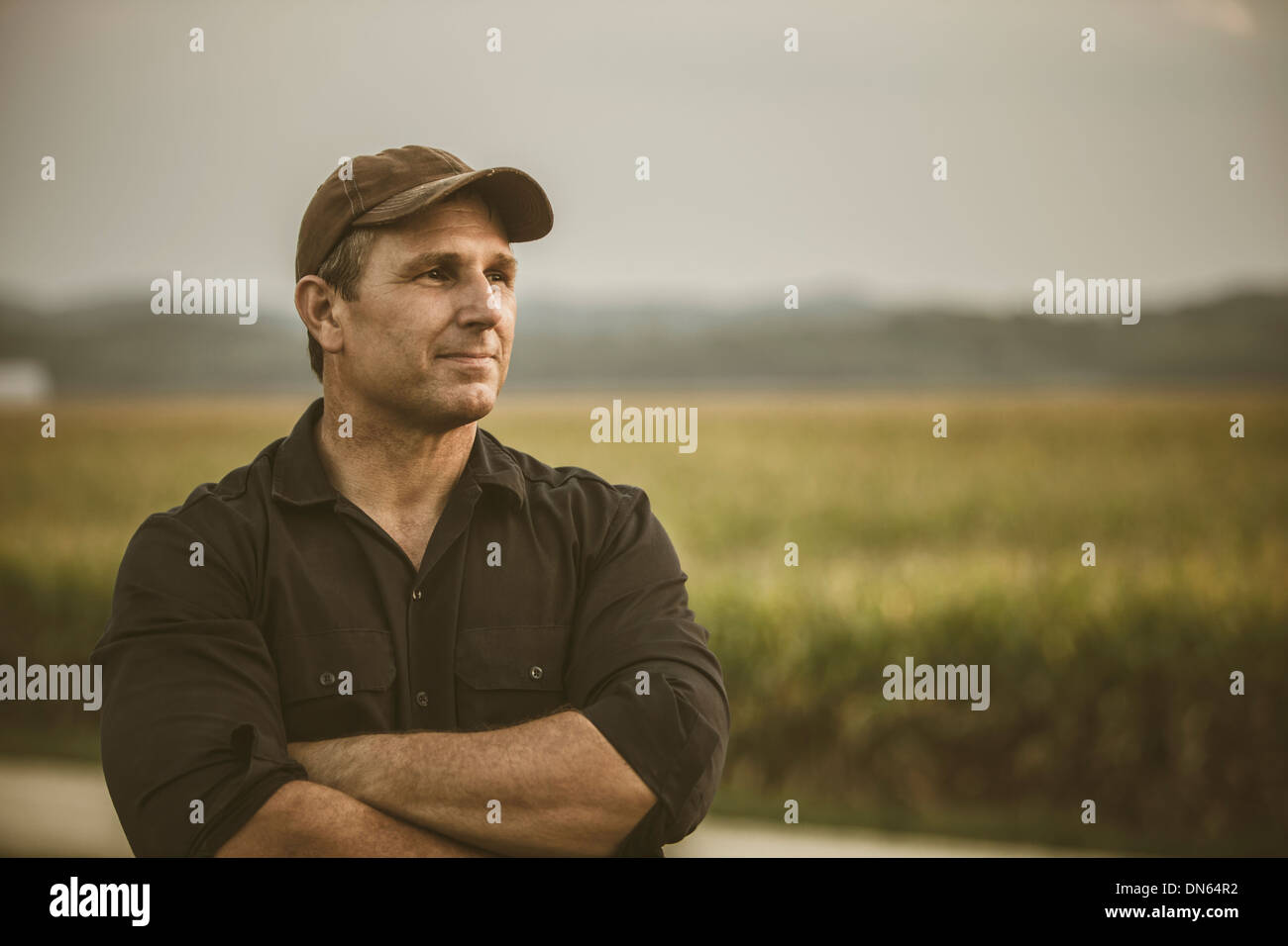 Caucasian farmer overlooking crop fields Stock Photo