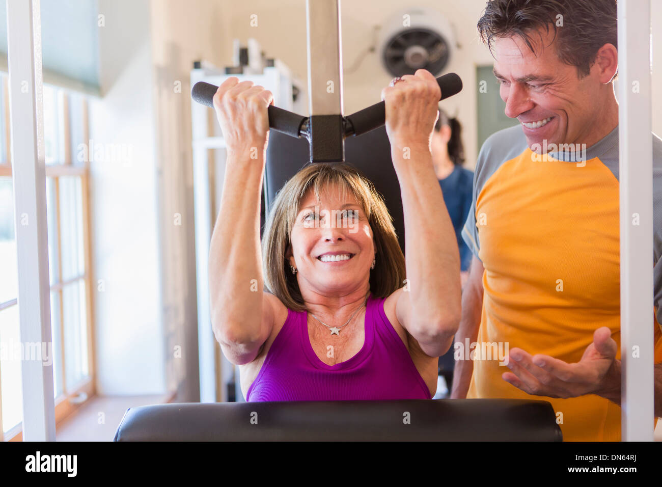 Caucasian woman working with personal trainer in gym Stock Photo - Alamy