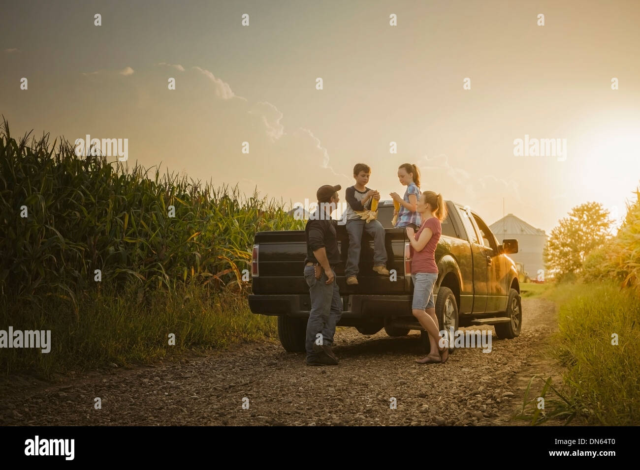 Caucasian family on truck on dirt road Stock Photo