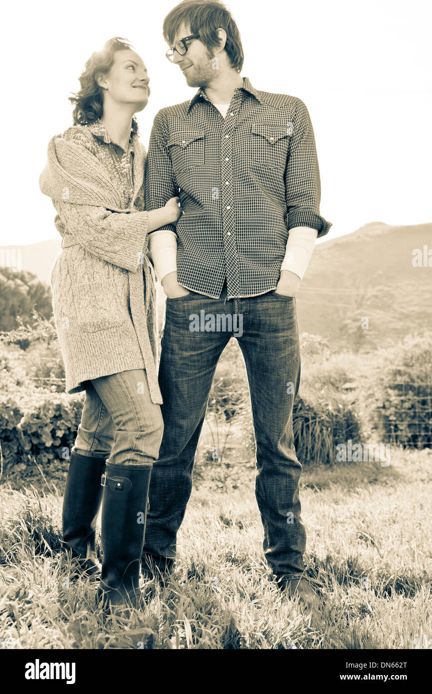 Couple standing in rural field Stock Photo - Alamy