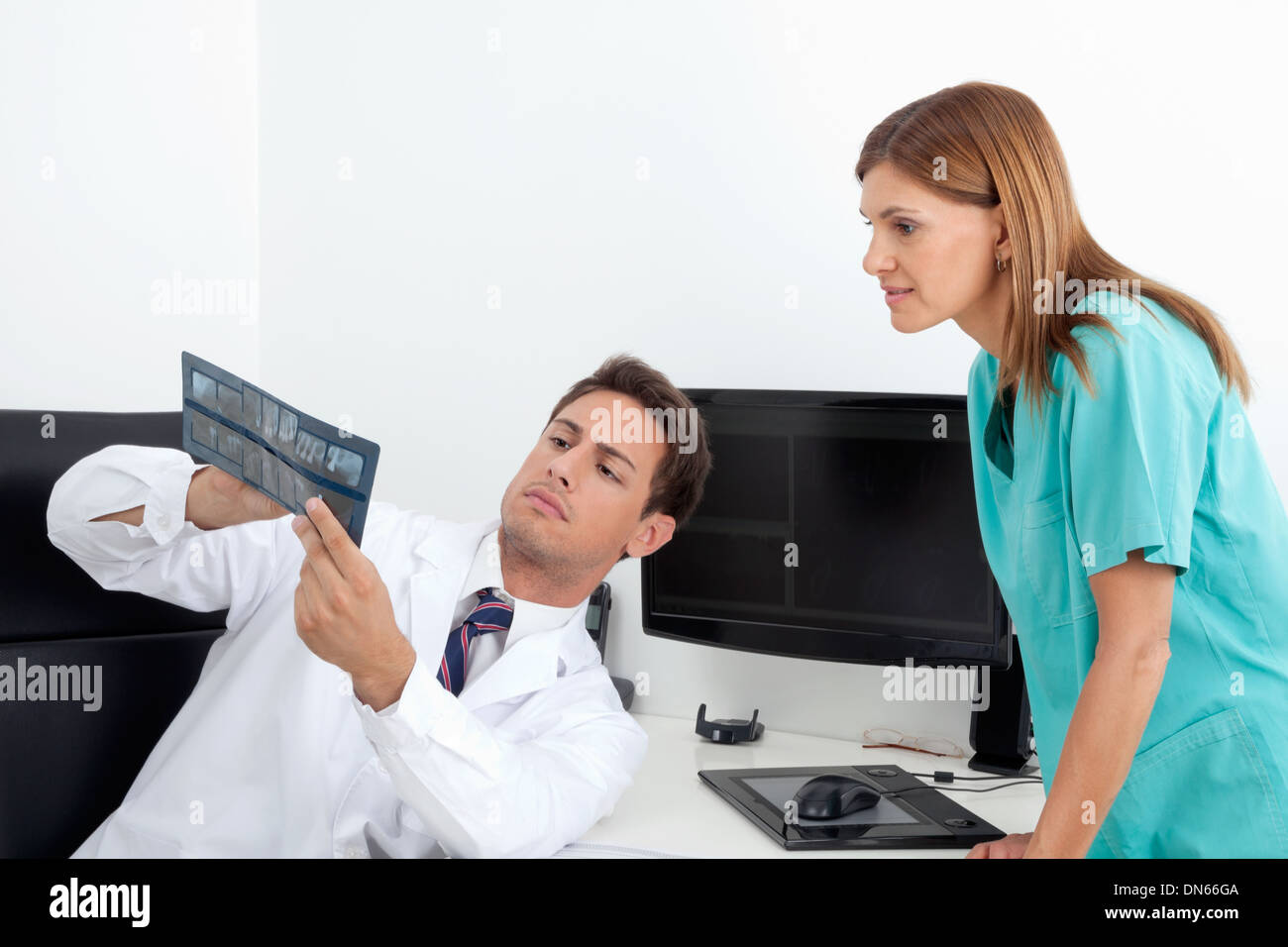 Dentist Analyzing X-Ray With Assistant Stock Photo