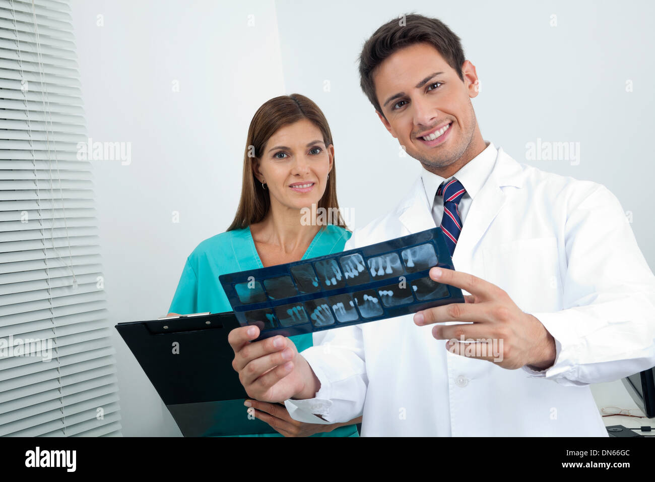 Doctor And Assistant With Patient's Report Stock Photo