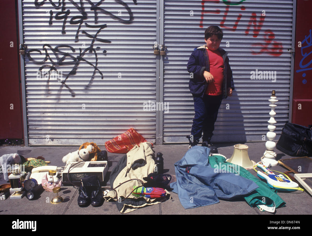 Childhood poverty boy selling family unwanted stuff the north end and less fashionable part of Portobello Road 1990s 1999 UK HOMER SYKES Stock Photo