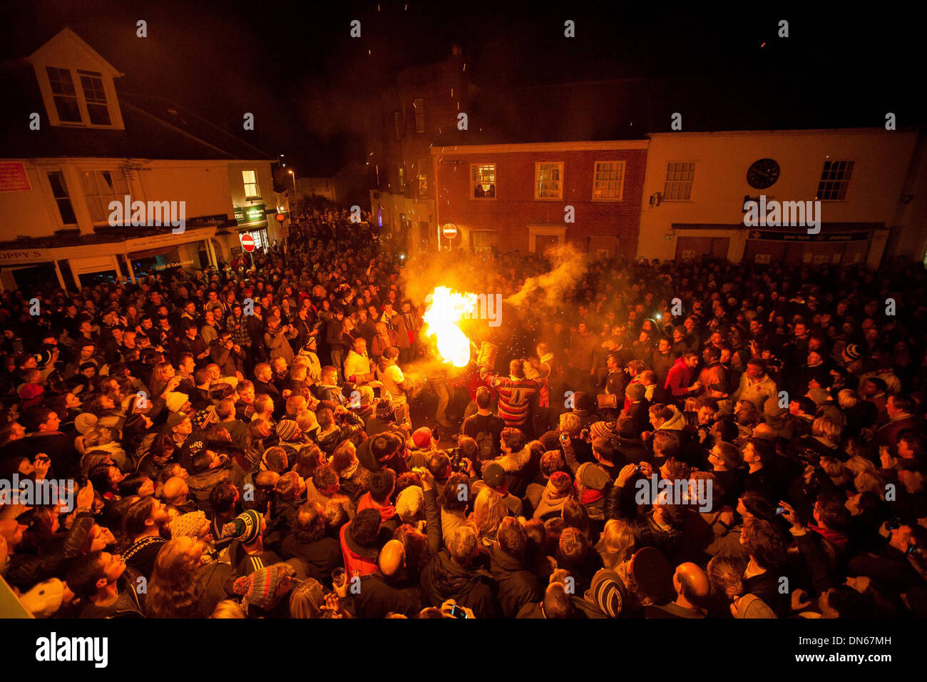 Participants run with a burning tar barrel through the streets of Ottery St Mary, Devon. Stock Photo