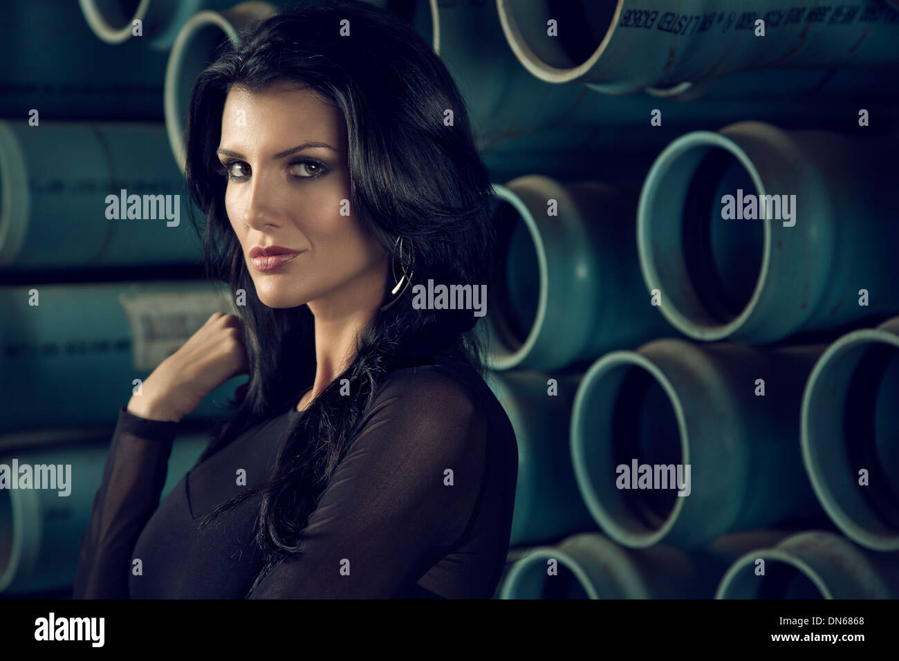 Fashion portrait of woman standing in front of pipes Stock Photo