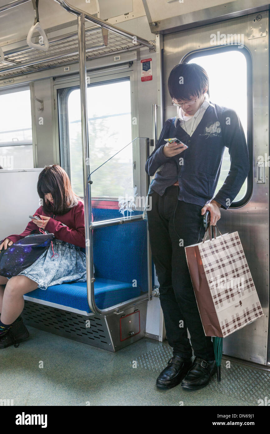 Japan, Honshu, Kanto, Tokyo, Young People on Train Stock Photo