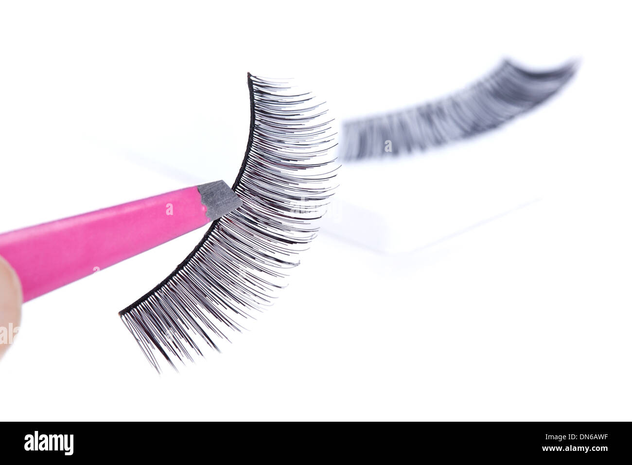 False lashes and pink pincers, closeup on white background  Stock Photo