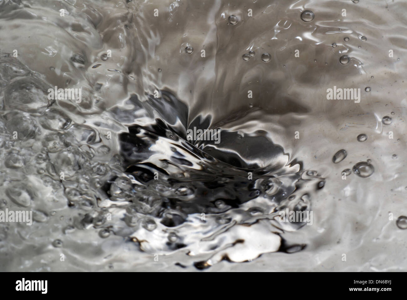 Close up of sink with water wirpool Stock Photo