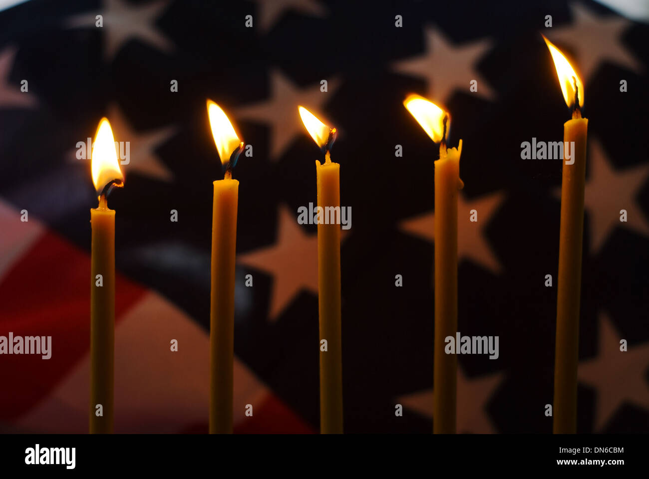 Lighted candle with an old American flag Stock Photo