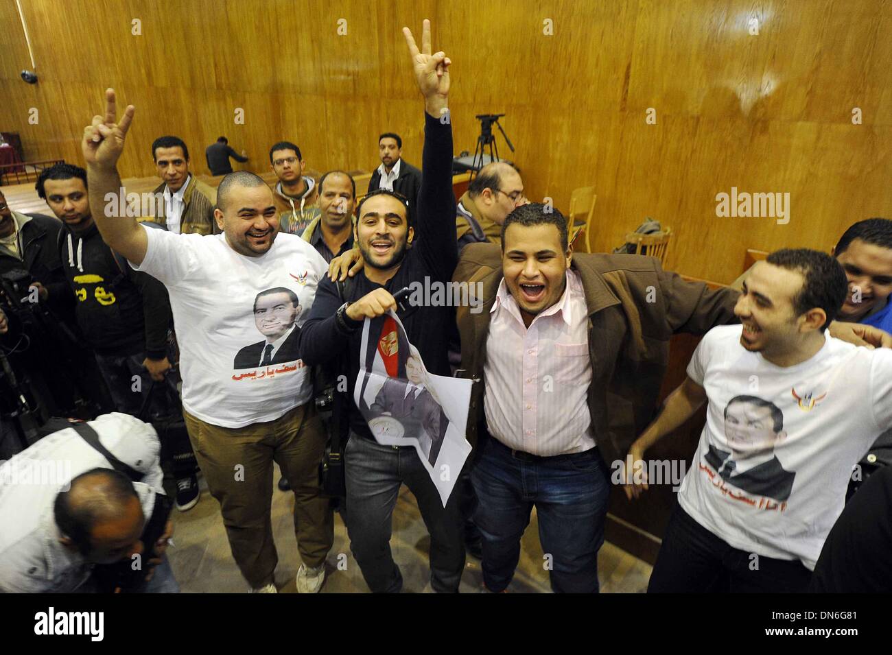 Cairo, Egypt. 19th Dec, 2013. Supporters of former Egyptian leader Hosni Mubarak celebrate at a court in Cairo, Egypt on Dec. 19, 2013. An Egyptian court on Thursday ordered to acquit Mubarak's two sons Alaa and Gamal, and former prime minister Ahmed Shafiq, who were charged of misuse of public funds, Middle East News Agency reported. Credit:  Ahmed Omar/Xinhua/Alamy Live News Stock Photo