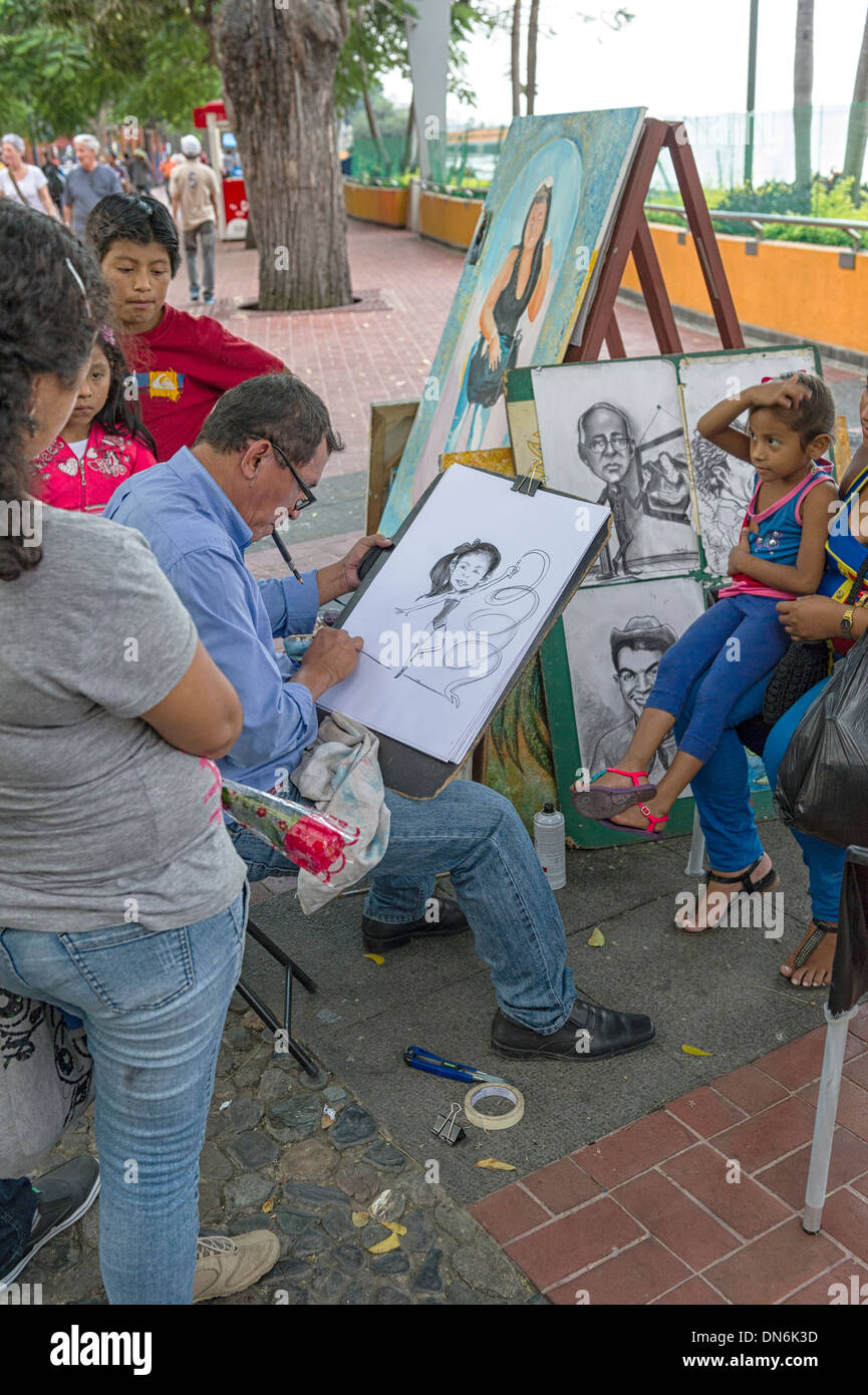 People on the Malecon 2000 have their portraits drawn in caricature style. Guayaquil Ecuador Stock Photo