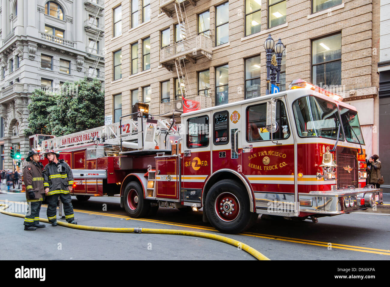 Two firefighters near a fire truck in a street of downtown San Francisco, California, USA Stock Photo