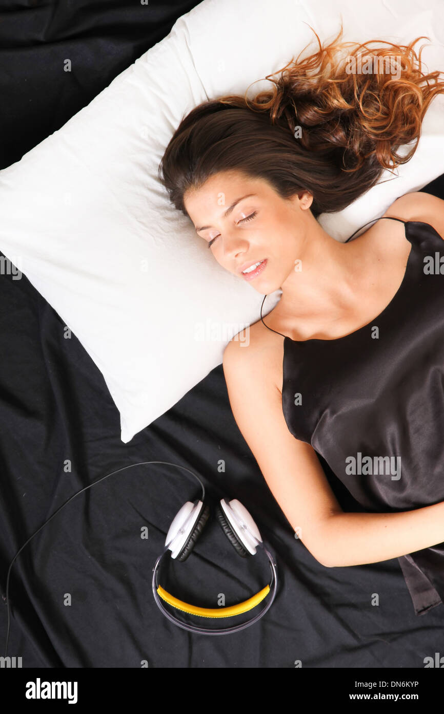 A young girl sleeping in bed with headset Stock Photo Alamy