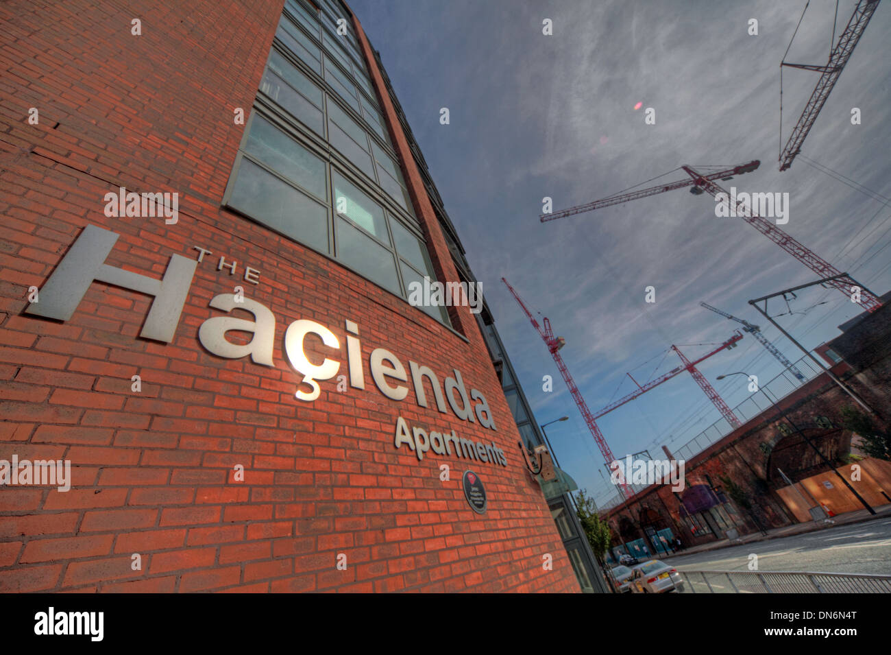 The Haçienda Apartments on Whitworth Street West, Manchester, with construction cranes rising behind the former FAC51 site. Stock Photo