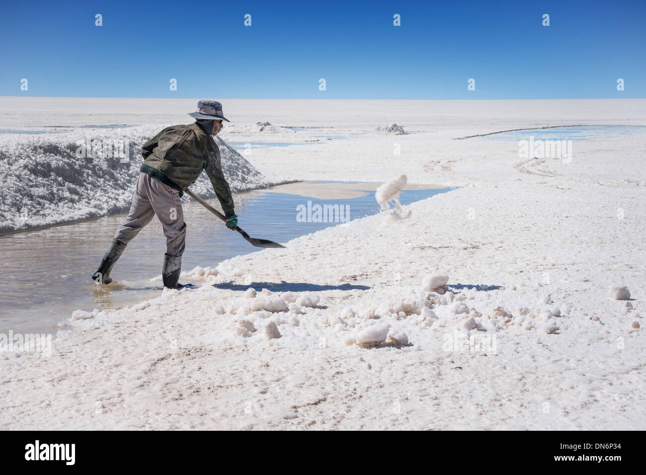 Bolivian salt miners, men extracting salt from Uyuni salt flats, Salar de Uyuni, Bolivia, South America Stock Photo