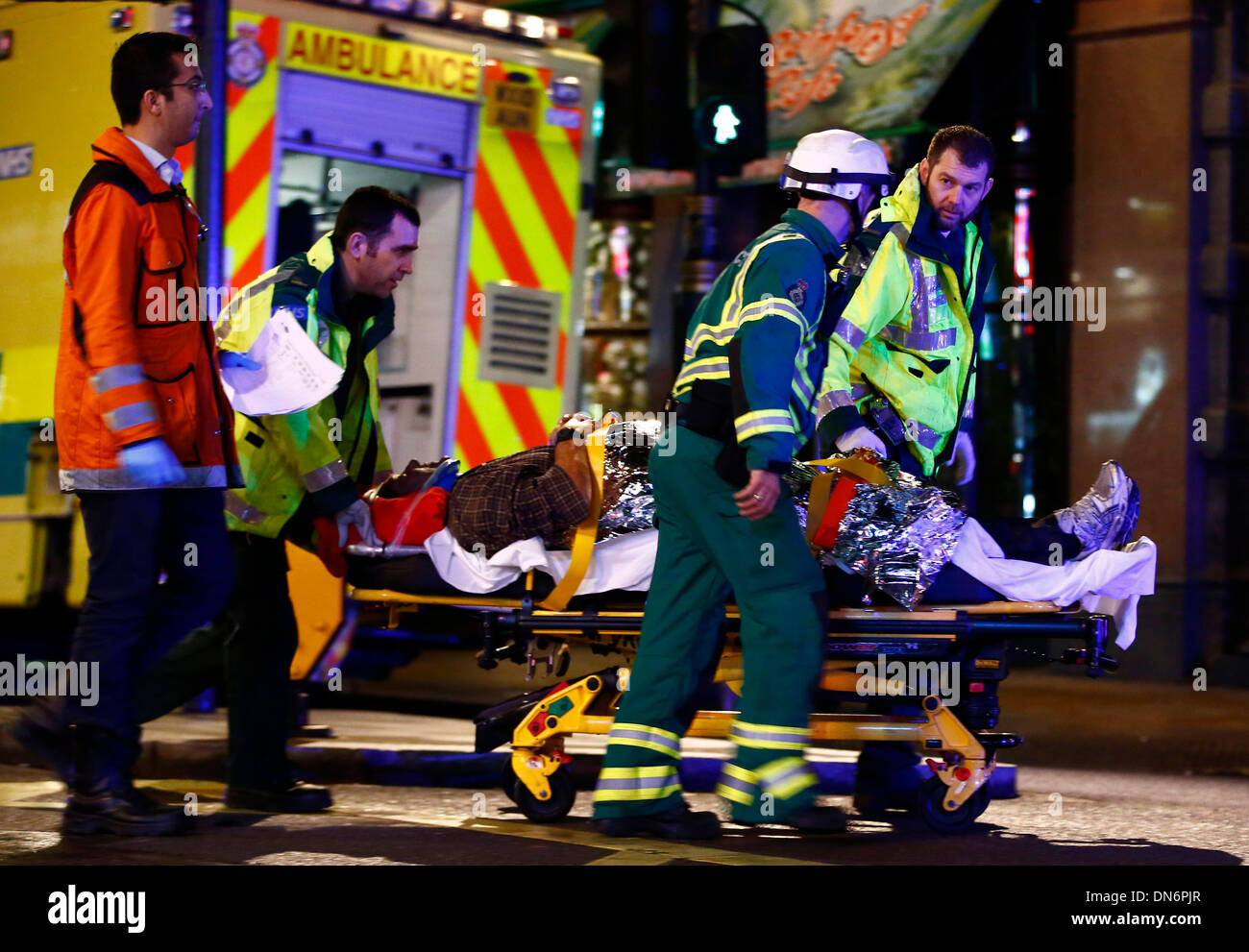 London. 19th Dec, 2013. An injured man is taken towards a waiting ambulance on a stretcher following a roof collapse at Apollo Theatre in Central London on Dec. 19, 2013. Some 88 people were injured, including 7 serious cases, after part of the roof in London's Apollo Theatre collapsed on Thursday. Credit:  Yin Gang/Xinhua/Alamy Live News Stock Photo
