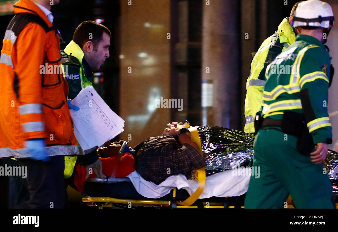London. 19th Dec, 2013. An injured person is taken towards a waiting ambulance on a stretcher following a roof collapse at a theatre in Central London on Dec. 19, 2013. Some 88 people were injured, including 7 serious cases, after part of the roof in London's Apollo Theatre collapsed on Thursday. Credit:  Yin Gang/Xinhua/Alamy Live News Stock Photo