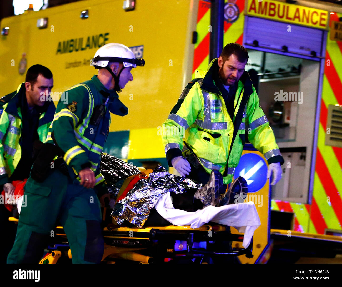 London. 20th Dec, 2013. An injured person is taken towards a waiting ambulance on a stretcher following a roof collapse at a theatre in central London on Dec. 19, 2013. Some 88 people were injured, including 7 serious cases, after part of the roof in London's Apollo Theatre collapsed on Thursday. Credit:  Yin Gang/Xinhua/Alamy Live News Stock Photo
