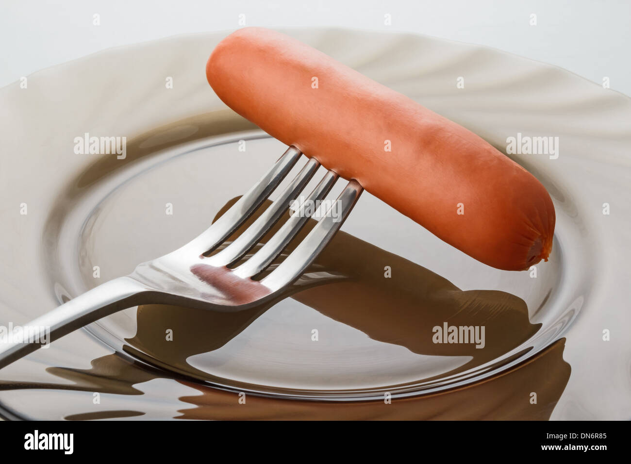 a freshly cooked sausage on a fork Stock Photo