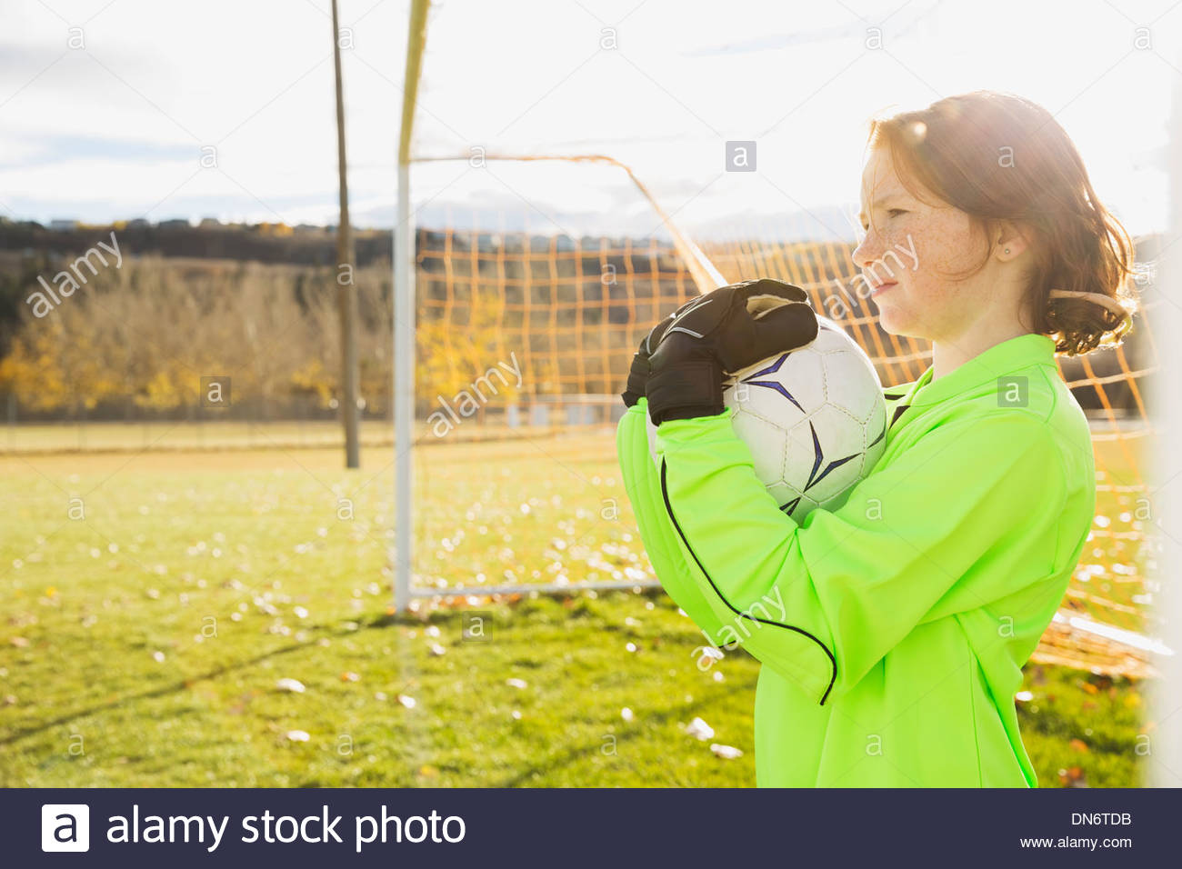 Goalie holding ball on soccer field Stock Photo Alamy