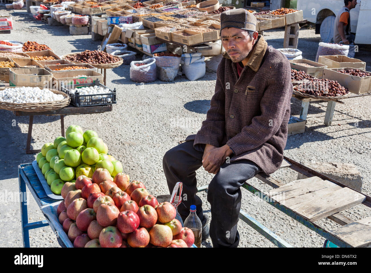 Man selling apples in an outdoor market, near Samarkand, Uzbekistan Stock Photo