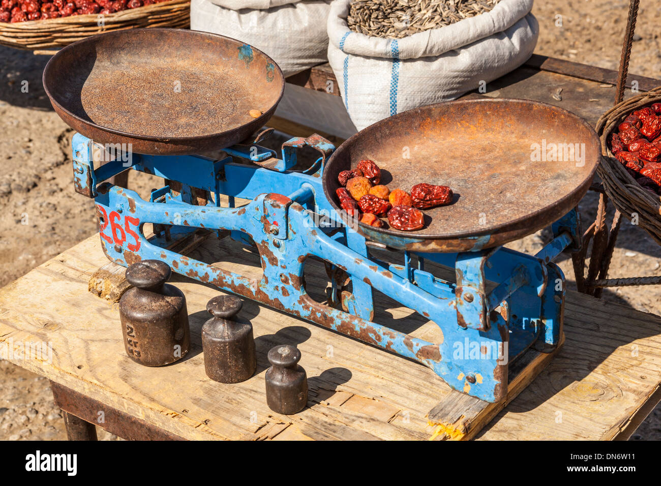 Old weighing scales and weights in an outdoor market, near Samarkand, Uzbekistan Stock Photo