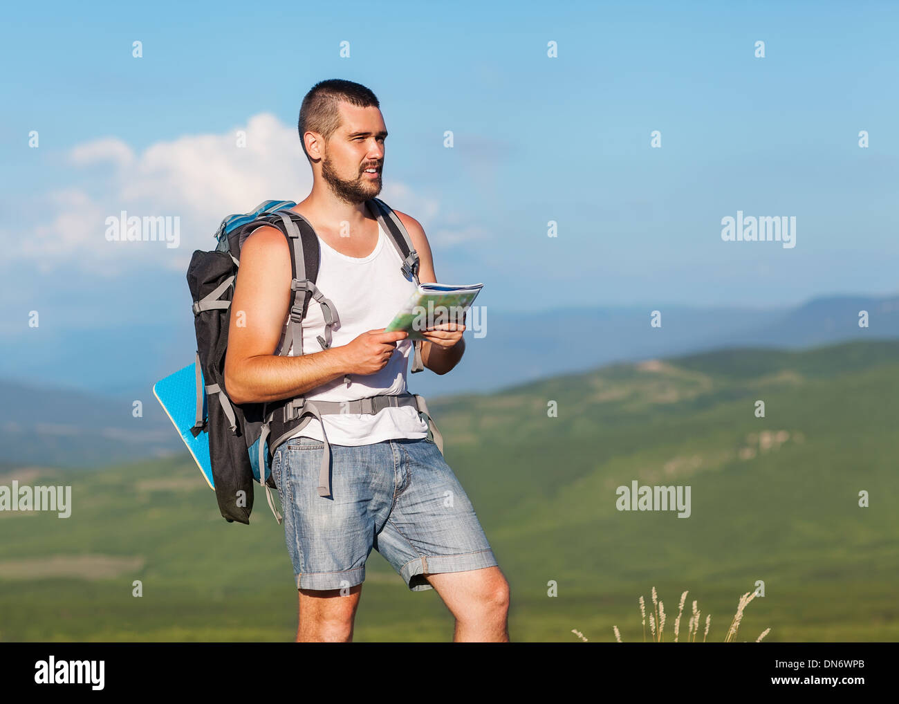 Hiker with backpack standing on top of a mountain with map Stock Photo ...
