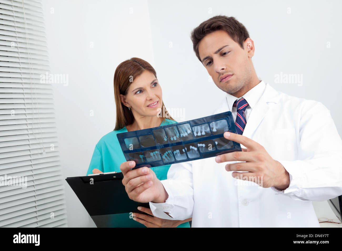 Doctor And Assistant Analyzing Patient's Report Stock Photo